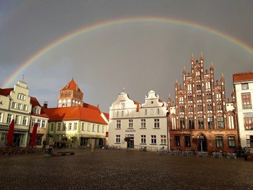 Regenbogen über dem historischen Marktplatz von Greifswald.