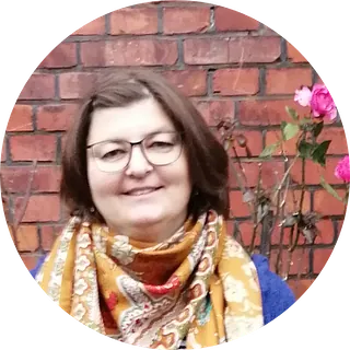 Lächelnde Frau mit Brille und einem bunten Schal.