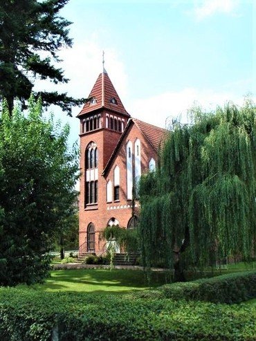  Rote Backsteinkirche mit hohem Turm.